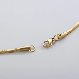 Detailed macro view of the gold lobster clasp and smooth metal texture of the snake chain