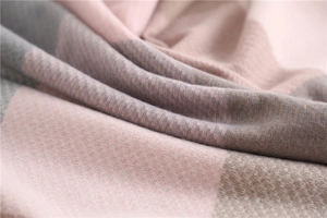 Macro shot of soft pink and grey checkered fabric texture of this winter scarf