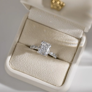 Macro view of a rectangular-cut zircon silver ring with side stones in a velvet box