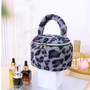 Detail view of a plush leopard print cylinder makeup bag with vibrant rainbow zipper.