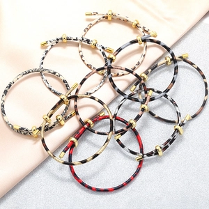 Detailed view of various leopard and snake print bracelets with golden adjustable clasps