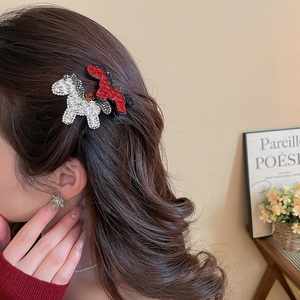 Close-up of red and silver rhinestone-encrusted puppy hair clips worn on a model