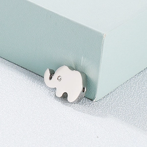 Polished silver elephant pendant with sparkling crystal eye on textured grey background