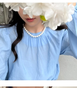 Collier de perles élégant de style français porté par un mannequin dans un cadre doux