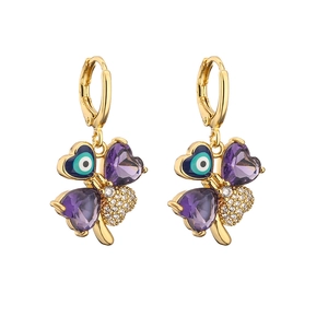 Detail of gold four-leaf clover earrings with purple heart stones and blue evil eye charms