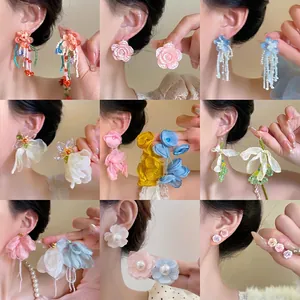 Collection of various floral earrings including beaded tassels and satin petal designs
