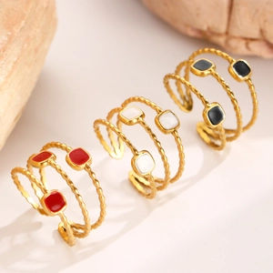 Gros plan de trois bagues spirales multicouches plaquées or 18 carats avec émail coloré