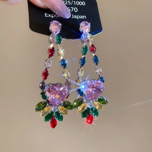 Close-up of pink heart-shaped crystal earrings with colorful gemstones on a silver base