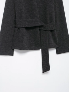 Close-up of the waist belt design and knitted fabric texture on the dark grey coat