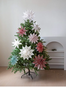 Detailed view of 3D paper star ornaments on a Christmas tree with Nordic hollow pattern