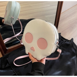 Detail view of round skull crossbody bag with pink heart nose and adjustable strap