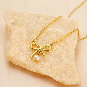 Elegant gold bow necklace with white pearl pendant on minimalist chain for women