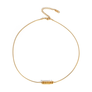 Detail of golden snake chain necklace featuring a spiral bead pendant and lobster clasp