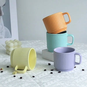 Set of minimalist striped ceramic mugs in macaron colors on a stylish tabletop