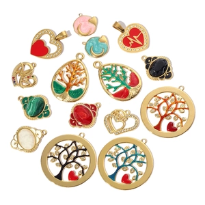 Flat lay of colorful enamel Tree of Life and heart-shaped titanium steel gold charms