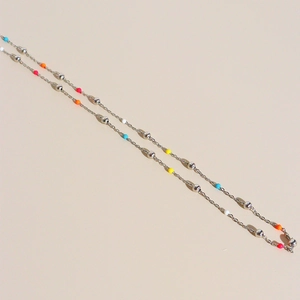 Minimalist silver titanium steel necklace with colorful beads on a beige background