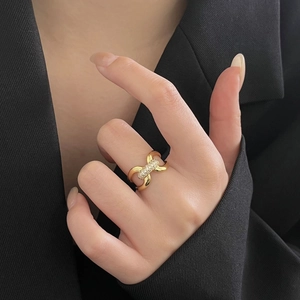 Detailed view of an adjustable gold knotted ring with pavé-set diamonds on finger