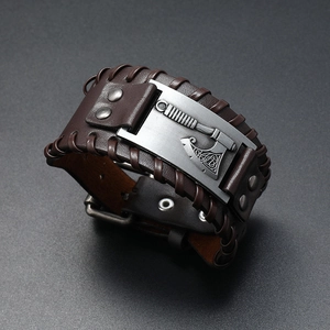 Detail of braided dark brown leather bracelet with an antique silver Viking axe charm