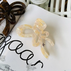 Detail showing marble texture beige and tortoiseshell acetate butterfly hair claw clips