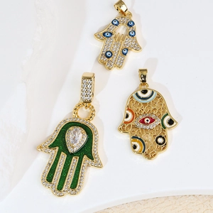Tre ciondoli Mano di Fatima in metallo dorato con occhi in smalto colorato e cristalli