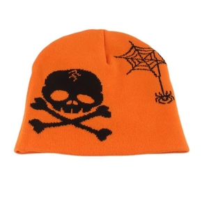 Close-up of orange knitted beanie featuring black skull and spider web patterns