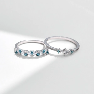 S925 sterling silver rings set with mint green and white crystals on white background