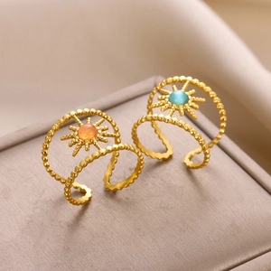 Double band stainless steel star rings with orange and blue gemstones on a jewelry box
