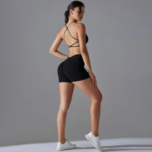 Detail view of seamless black cross-back sports bra and high-waisted fitness shorts