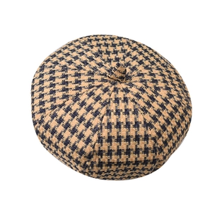 Detailed view of yellow and black houndstooth pattern and stitching on wool beret hat