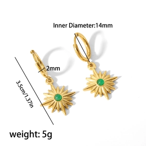Detailansicht goldener Creolen mit Sternanhängern und grünen Edelsteinen im Detail