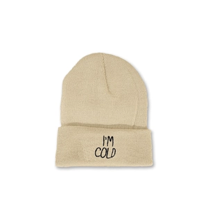 Close-up of I'M COLD embroidery on beige ribbed knit beanie with soft winter texture