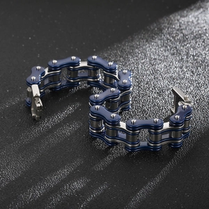 Macro detail of blue and silver bicycle chain bracelet on a black textured background