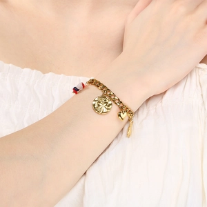Detail view of 18K gold plated chain bracelet with heart, rose and rabbit charms on wrist