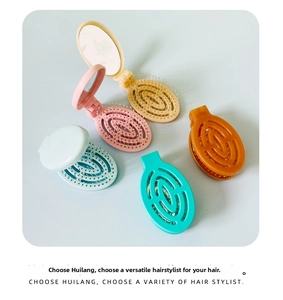 Detailed view of portable folding hairbrush with mirror and massage bristles in five colors