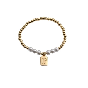 Close-up of gold beads and white pearls bracelet with a rectangular letter P charm