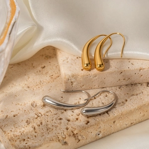 Water-drop earrings in 16K gold and silver finish on a natural stone base