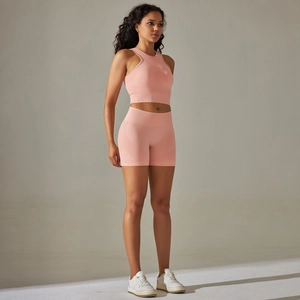 Detail of seamless ribbed pink workout set showing a crop top and high-waisted shorts