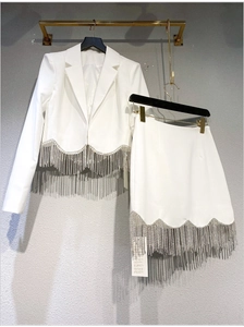Detail of white cropped blazer and skirt set featuring silver rhinestone tassel fringes