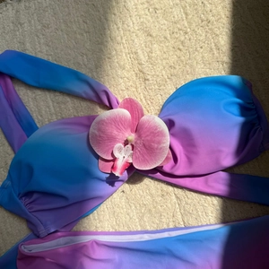 Gros plan du bikini dégradé bleu et violet avec fleur d'orchidée en tissu 3D