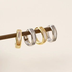 Macro shot of S925 silver hoop earrings with natural mother-of-pearl in gold and silver