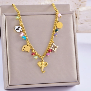 Detail of gold lucky elephant necklace with colorful enamel fish and beads on a jewelry box