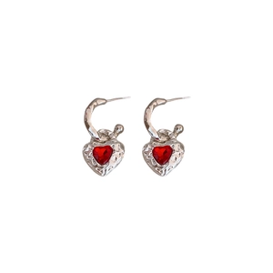 Elegant textured silver heart earrings with vibrant red gemstone pendants on white background