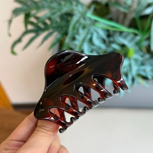 Détail d'une pince à cheveux motif écaille de tortue marron foncé avec finition brillante