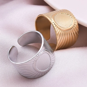 Detail of gold and silver stainless steel rings with radial texture on purple silk