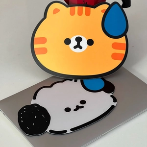 Detail view of Chunsik cat and white dog shaped mouse pads on a laptop surface