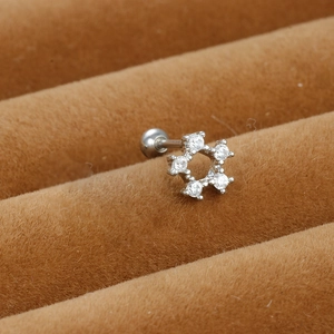 Macro detail of silver stainless steel cartilage stud with five-pointed star zircon stones