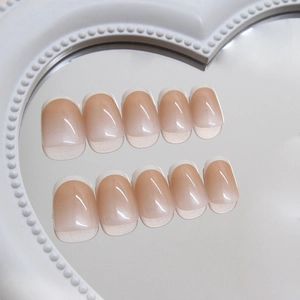 Classic French tip press-on nails with nude gradient and glossy finish on heart tray