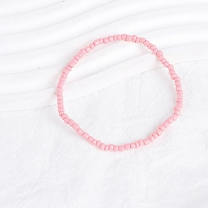 Detailed view of pink bohemian beaded bracelet set on a white textured background