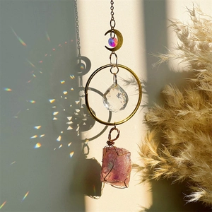Detailed close-up of crystal suncatcher with amethyst and golden moon ornament