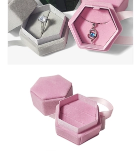 Detail of hexagonal velvet jewelry boxes with elegant ribbons in pink, grey and green